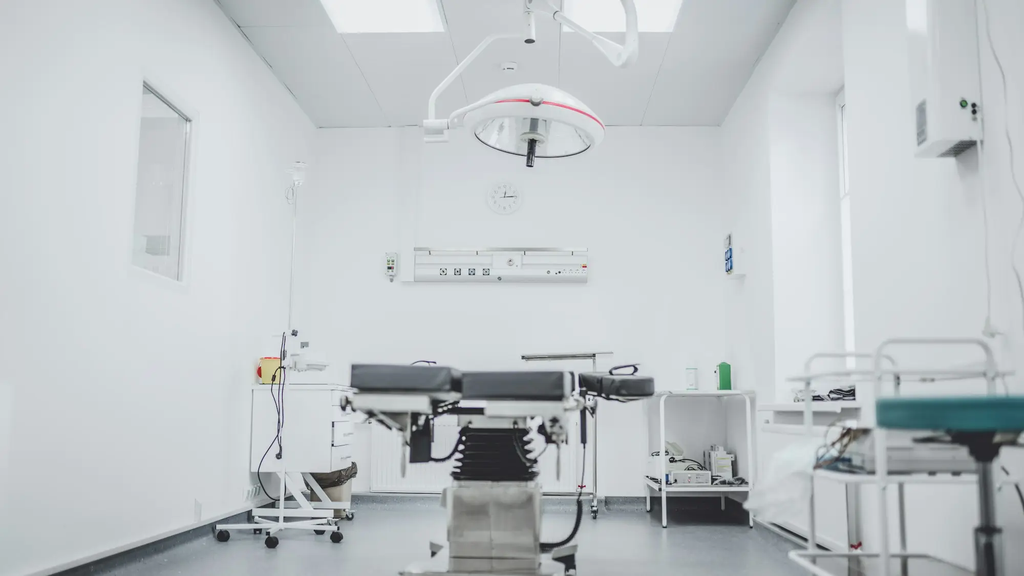 Treatment room with a procedure table, overhead light and medical equipment