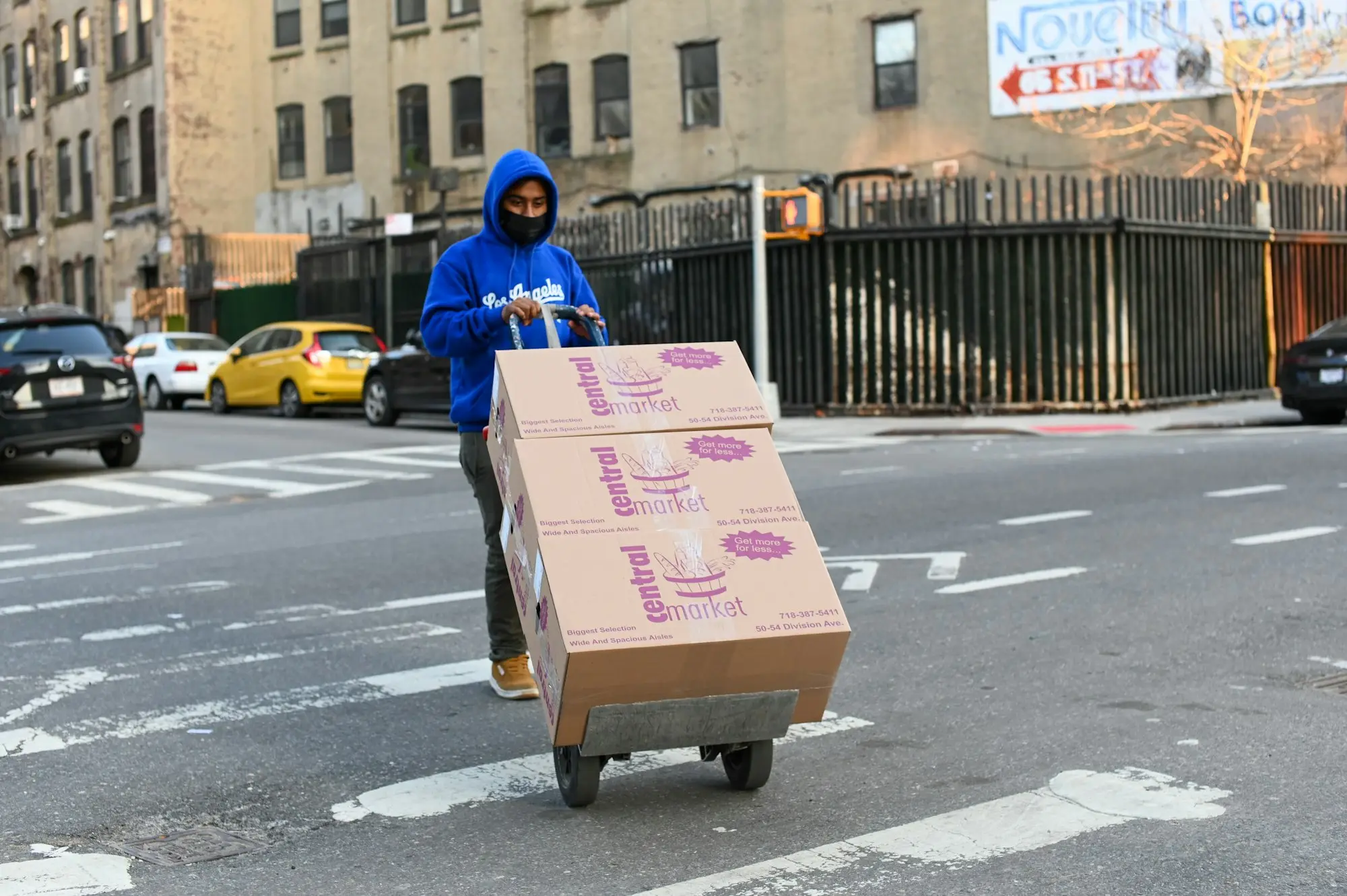 Worker carrying a cardboard box of stock from a fresh inventory order